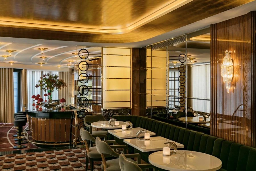 Luxurious Paris restaurant interior with art deco design, mirrored walls, velvet seating, and an elegant cocktail bar.