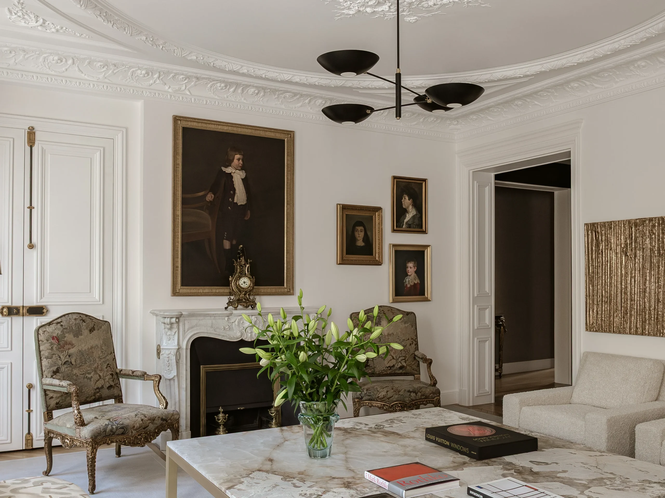Elegant Paris interior showcasing Haussmannian architecture, decorative cornices, and restrained contemporary lighting design