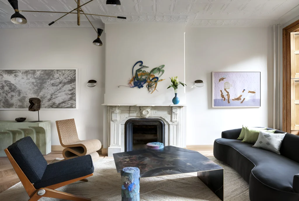 Contemporary Paris apartment living room featuring sculptural seating, curated art, and a minimalist fireplace, blending modern design with classic architectural details.