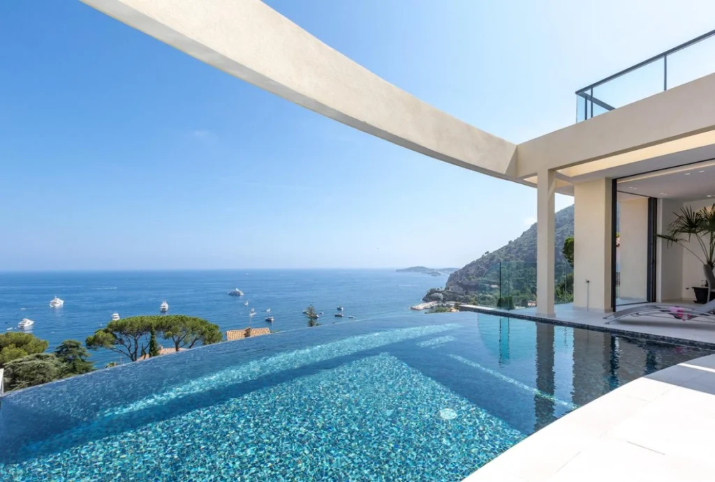 Luxury coastal architecture on the Riviera with a modern infinity pool overlooking the Mediterranean Sea, defined by minimalist lines and seamless indoor-outdoor living.