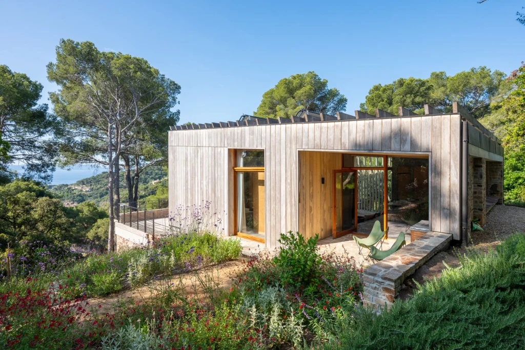 Modern Mediterranean coastal home set within a natural landscape, showcasing sustainable luxury architecture, timber cladding, and panoramic Riviera views.