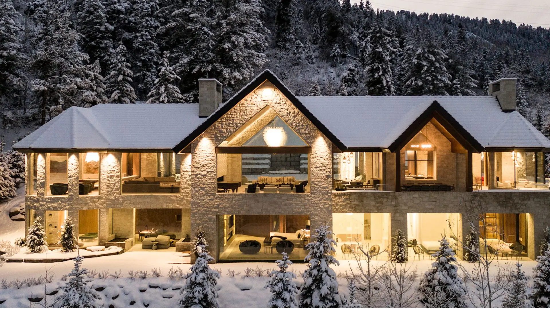 Aspen luxury homes showcasing refined mountain home interior design and seasonal residence furnishing, featuring contemporary alpine architecture, natural wood and stone materials, panoramic mountain views, elegant living rooms with fireplaces, and seamless indoor-outdoor living in Colorado.
