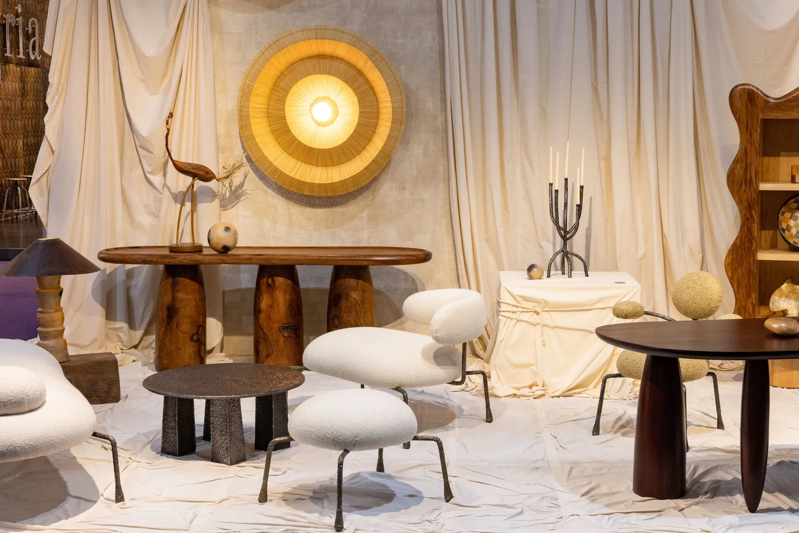 Curated furniture installation at an international design fair featuring sculptural seating, artisanal tables, and natural materials, highlighting emerging furniture trends from design fairs.