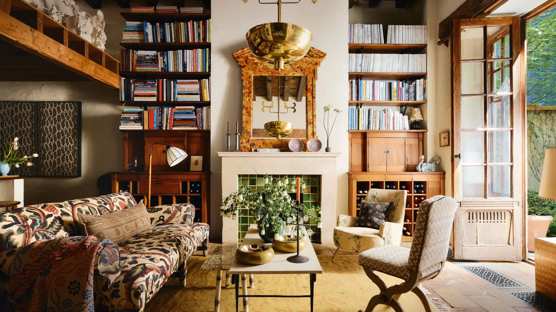 Luxury interior design showcasing Manhattan penthouse interiors with panoramic skyline views and double-height living spaces alongside refined Paris pied-à-terre design in a classic Haussmann apartment, featuring bespoke furniture, natural stone dining tables, artisan-crafted seating, and elegant architectural details blending modern sophistication with historic character.