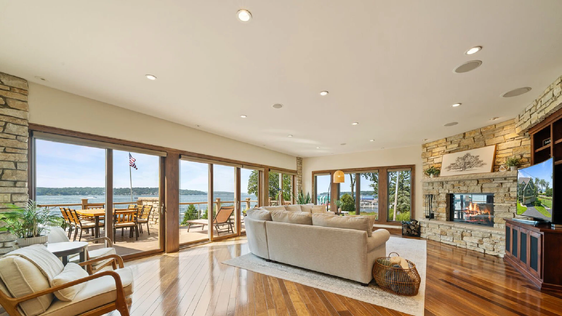 Luxury living room in a Geneva lakefront home with a low-profile neutral sofa positioned toward floor-to-ceiling windows overlooking Lake Geneva, illustrating refined living room seating arrangement and luxury waterfront interior design.