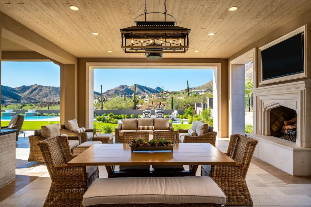 Covered outdoor living room designed as an extension of the interior, featuring lounge seating and panoramic desert views