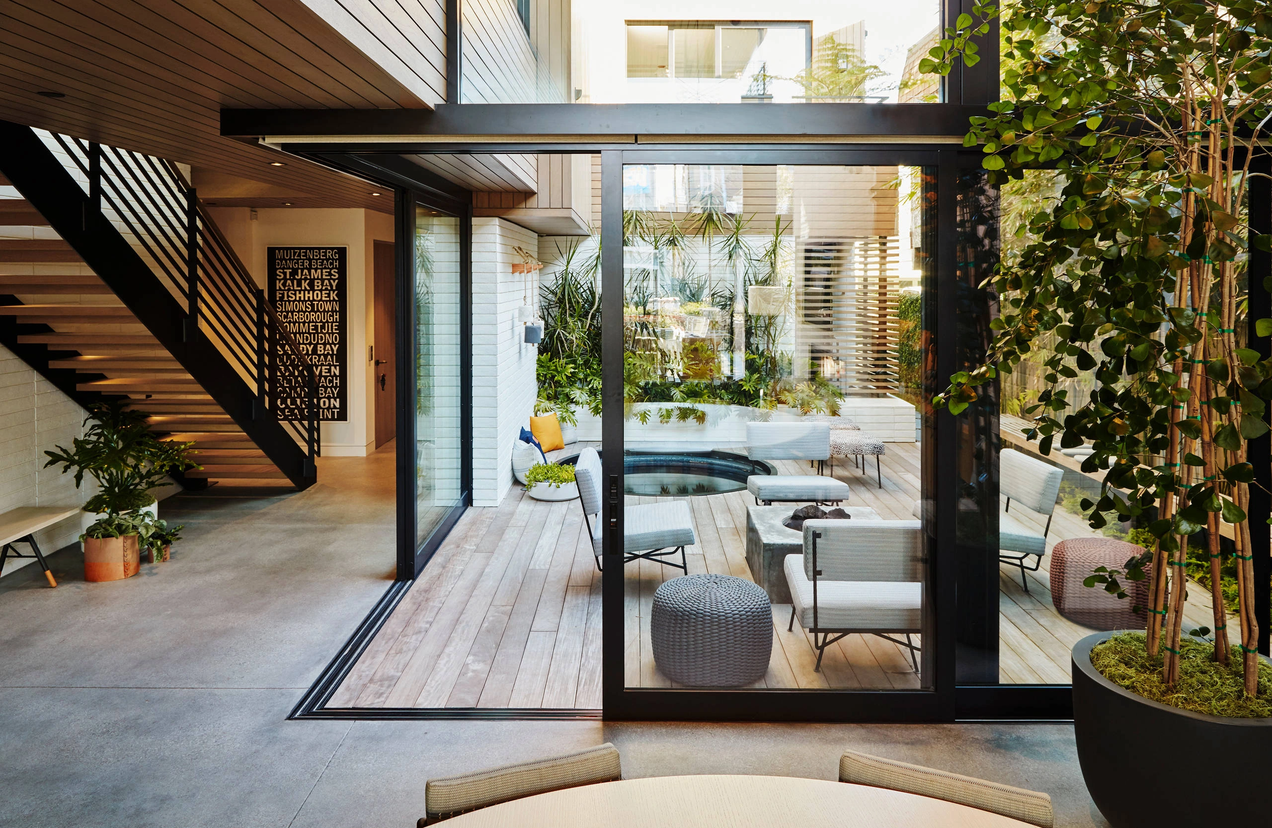 Contemporary courtyard home interior with indoor trees and fluid circulation between interior and exterior spaces