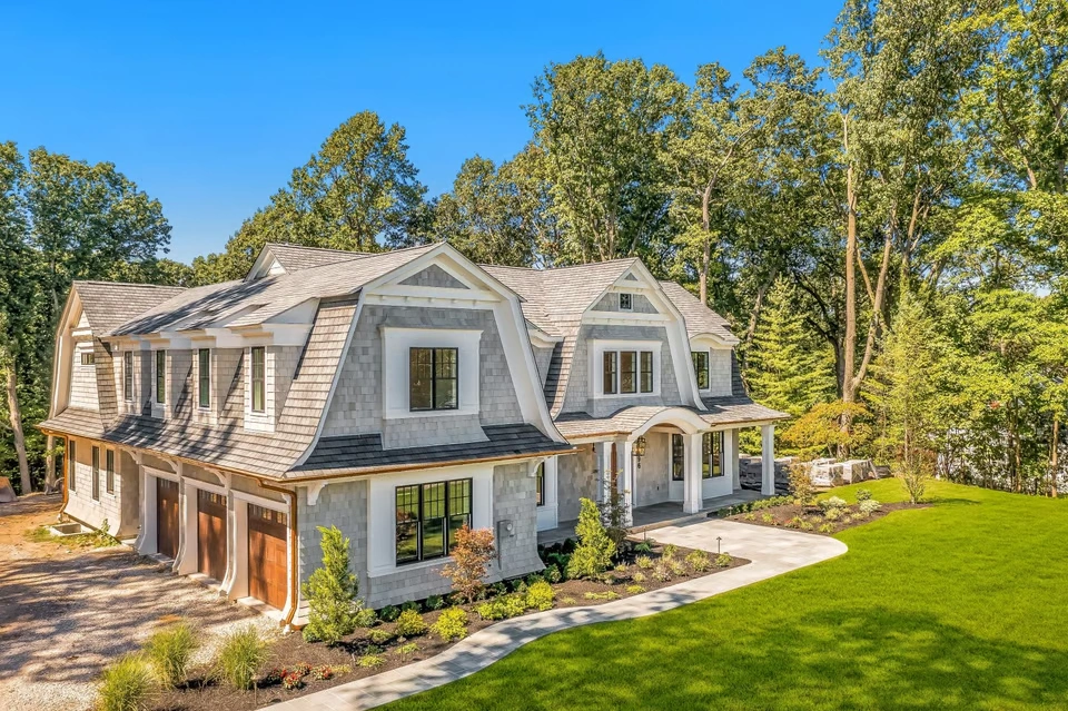 Luxury Hamptons-style East Coast summer home showcasing open-plan coastal interiors, cedar-shingle architecture, landscaped gardens, and a refined infinity pool setting that embodies timeless luxury coastal living.