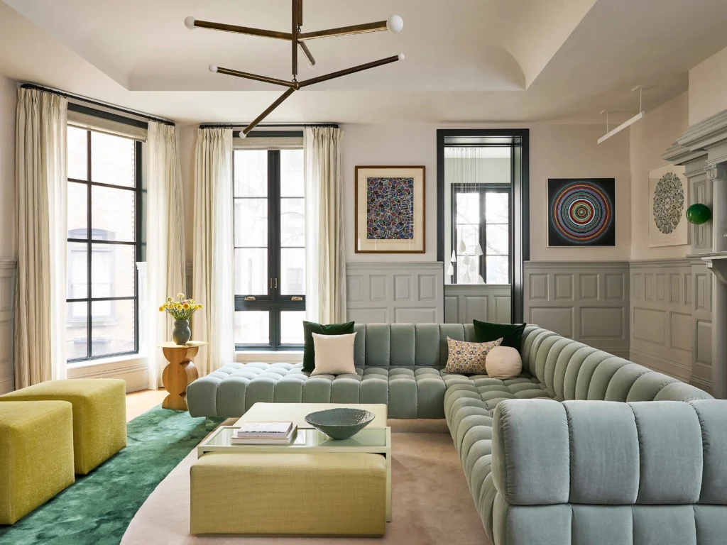 Bright open-plan home interior where dining and living furniture define spatial zones within a light-filled architectural framework.