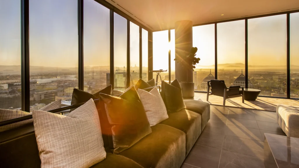 Contemporary luxury interior showcasing modern homes with open-plan living, floor-to-ceiling windows, bespoke kitchen with marble island, spa-inspired bathroom, curated entryway, private library, seamless indoor-outdoor terrace, and layered ambient lighting defining an elevated luxury lifestyle.