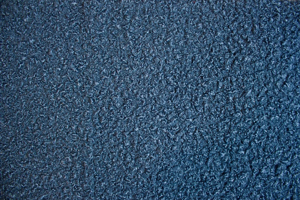 Detailed view of blue bouclé fabric texture, emphasizing tactile loops and material depth essential to proper bouclé fabric care in high-end upholstery