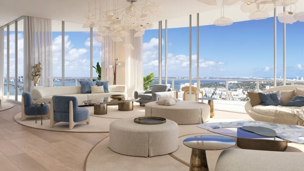 Expansive open-plan luxury living room in a Miami waterfront penthouse with floor-to-ceiling glass walls, contemporary designer furnishings, and panoramic ocean views flooding the interior with natural light.